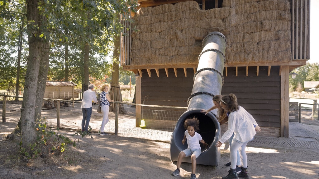 Kind gaat van de glijbaan in Kinderboerderij de Hooimijt in Efteling Loonsche Land