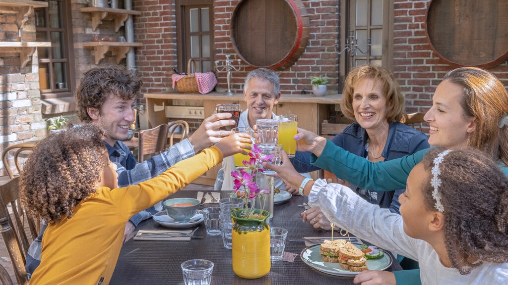 Een familie proostend aan tafel in Restaurant Het Eethuys in Efteling Bosrijk