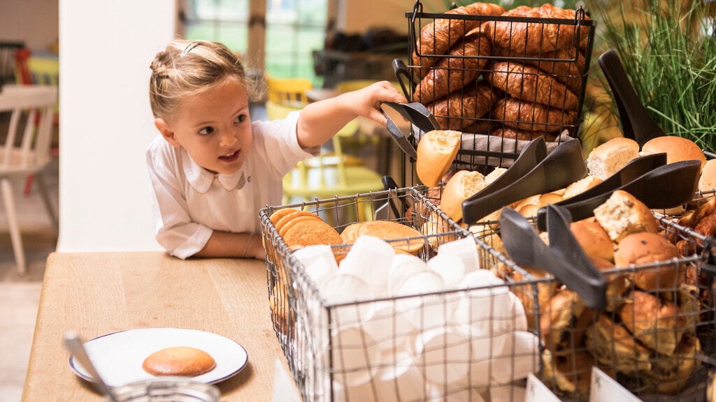 Meisje pakt een broodje van het ontbijtbuffet in Restaurant De Proeftuyn in Efteling Loonsche Land